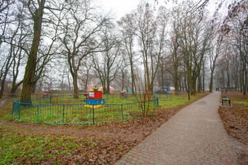 Empty foggy park with old playground equipment