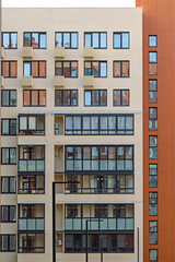 Modern apartment building facade with balconies and large windows in urban setting
