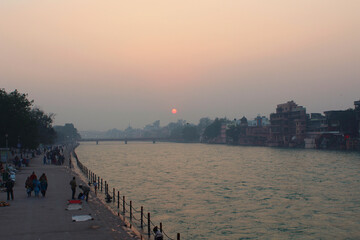 Obraz premium people walking in the footpath at the river ganga ghat in the evening