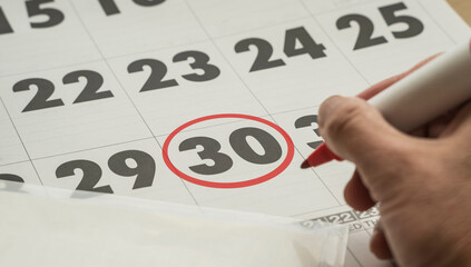 thirtieth day of the month marked with a red pen. Day 30 of the calendar marked with a red circle