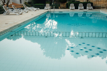 Piscine collective dans une résidence de vacances en Espagne. Chaises longues et transats  autour...