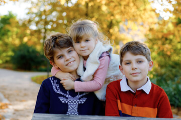 Portrait of three siblings children. Two kids brothers boys and little cute toddler sister girl...