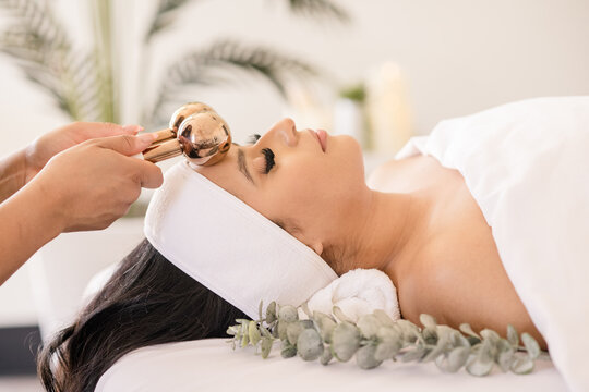 Women having ice globe massage on head