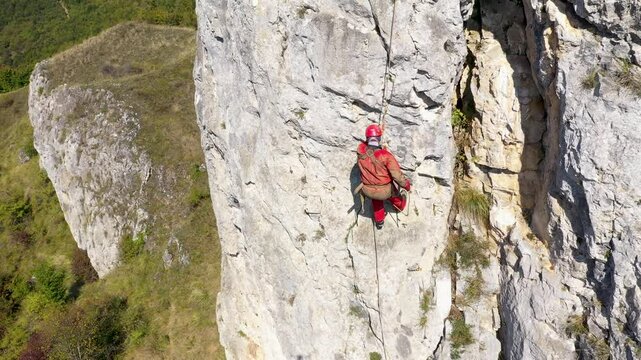 Aerial view of mountain rescuer doing rescue operations hanging on a rope