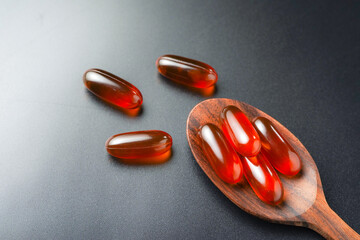 Vitamin capsules in a wooden spoon, soft gels, Fish oil capsules, omega 3, omega 9, vitamin D,...