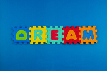 A close-up of foam puzzle pieces spelling out the word 