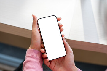 A woman relaxing in a coffee shop while using her smartphone.