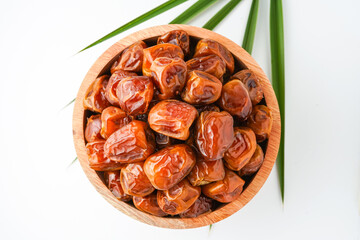 Dates fruit sukari or kurma sukari, in wooden bowl isolated on white background