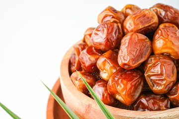 Dates fruit sukari or kurma sukari, in wooden bowl isolated on white background