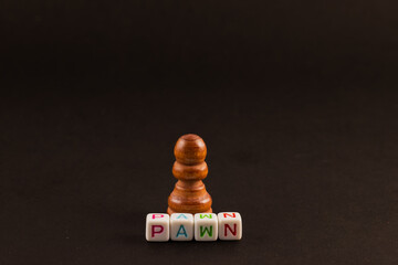 The chess pawn, a symbol of potential and possibility, stands alone against a dark background. The...