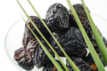 Dates fruit ajwa or kurma ajwa, in bowl isolated on white background