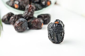 Dates fruit ajwa or kurma ajwa, in bowl isolated on white background