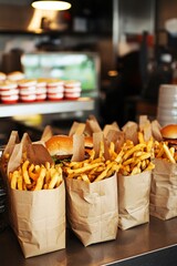 French fries in paper bags waiting for customers on a metal countertop