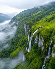 mystical foggy valley with gentle waterfalls cascading down lush green hills