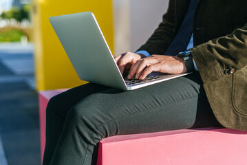 Businessman working on laptop outdoors in modern setting