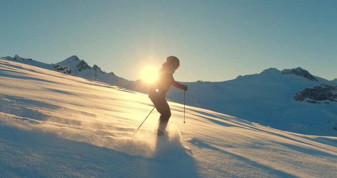 Male ski pro freeride skiing in fresh powder snow with beautiful sunset light in untrackt offpist backcountry. Follow camera skiing in the swiss alps with pro skier.
