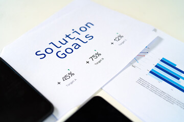 A document outlining solution goals with percentages and graphical data, likely related to business performance or project objectives.
