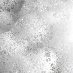 This is a close-up shot of a mass of white bubbles, perhaps soap suds or foam. The bubbles vary in size, and the light reflects off of them, creating a bright, textured effect.