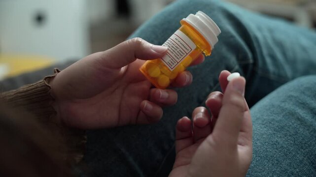 Healthcare medicine concept woman taking pill and pouring capsules from medication bottle&nbsp;at home