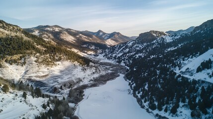 Obraz premium Snow-covered mountains under a clear sky, serene winter landscape with a river flowing through valleys, perfect for nature enthusiasts.