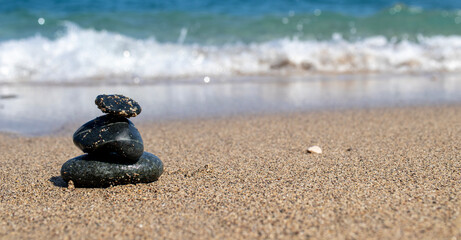 black stones on the beach, sea and waves.zen stones