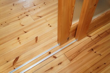 Sliding door between room of log house.