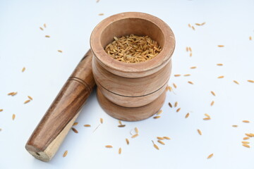 Pounding paddy with wooden mortar and pestle. Traditional method of food preparation. In the olden...