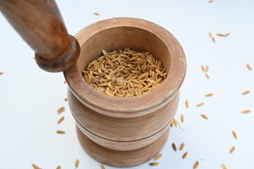 Pounding paddy with wooden mortar and pestle. Traditional method of food preparation. In the olden...