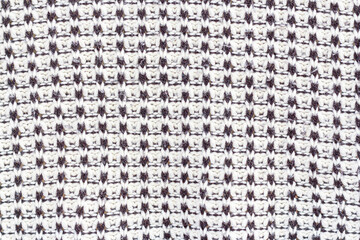 The fabric is hand knitted with black and white yarn.