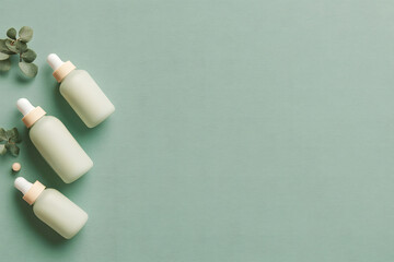 Minimalist Skincare Composition with Green Glass Dropper Bottles on a Pastel Green Background and Eucalyptus Leaves with copy space, Theme of organic beauty product concept.