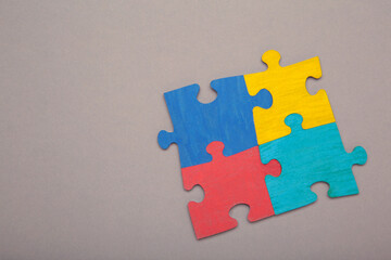 Fototapeta premium Colorful puzzle on grey background. Multi-colored heart as a symbol of World Autism Awareness Day. Top view