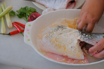 Hands of woman chef preparing fish food