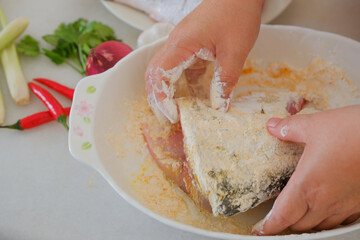 Hands of woman chef preparing fish food