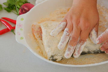 Hands of woman chef preparing fish food