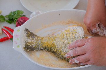 Hands of woman chef preparing fish food