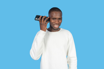 Young man listening on smartphone with blue background