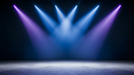The image shows four spotlights illuminating a concrete floor, creating a dramatic stage effect with purple and blue lighting.