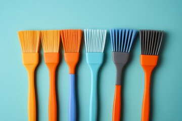 Colorful collection of silicone brushes arranged on a blue background for baking and cooking activities