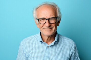 Mature man in glasses smiling and posing in studio for portrait photograph