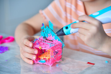 Young girl designer using 3d printing pen at home.