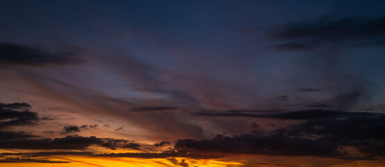 Sunset background. Dramatic majestic scenery sunset. Sky with clouds in sunset sky light background. Sunrise with clouds in various shapes. Calm sunset sky and sun through clouds over.