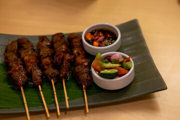 Indonesian Sate served on a plate with dipping sauces.