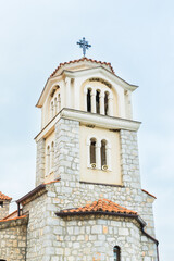 Majestic stone church with a bell tower, overlooking the serene waters of Lake Ohrid. The building weathered facade and traditional architecture reflect its rich history and cultural significance.