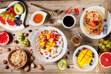 healthy breakfast or brunch with granola, oatmeal, pancakes and fresh fruits