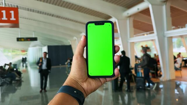 International airport hand holds phone with green screen chroma key. . High quality 4k footage