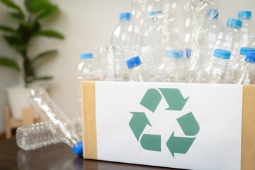 A box full of plastic bottles with a recycling symbol on it. Concept of recycling and the importance of reducing waste