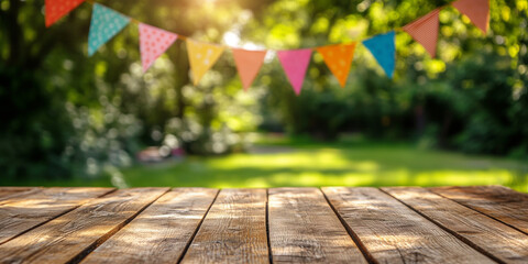 Wooden board table and blurred colorful summer garden party decoration flags setting in background.