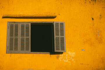 Un mur jaune et une fenêtre 