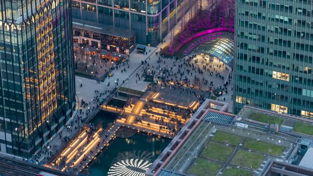 Time lapse view of the busy Canary Wharf financial district with commuter crowds of people rushing over the square from their offices in London, England