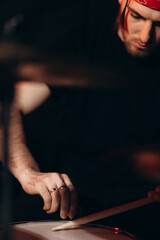 Focused Musician Playing Drums During Rehearsal in Studio